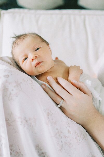 newborn baby laying on a cushion