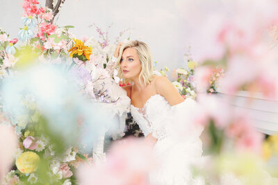 Bride posing while surrounded by colorful flowers