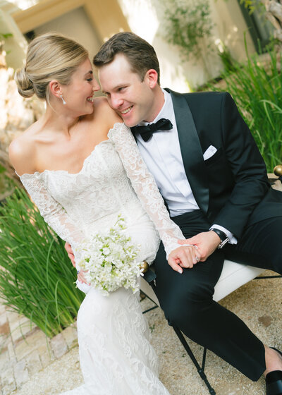 Flash photo of room sitting in a chair with bride sitting on the arm of the chair in front of wooden shelves