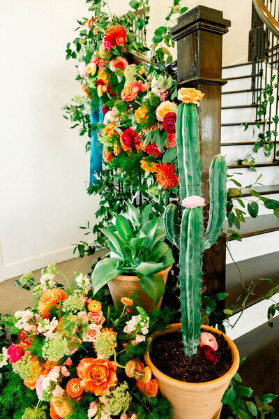 Vibrant floral staircase installation featuring bold coral, red, pink, and yellow blooms