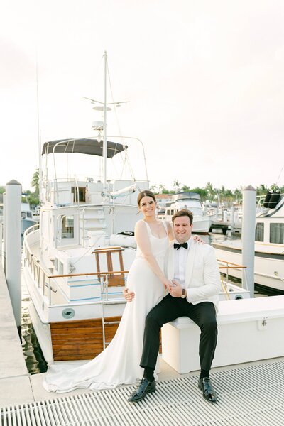 Bride and Groom sitting on a deck box at the Biscayne Yacht Club in Miami Florida