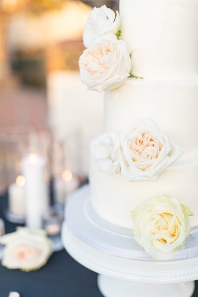 White wedding cake with blush and white roses at Hummingbird Nest Ranch Villa.