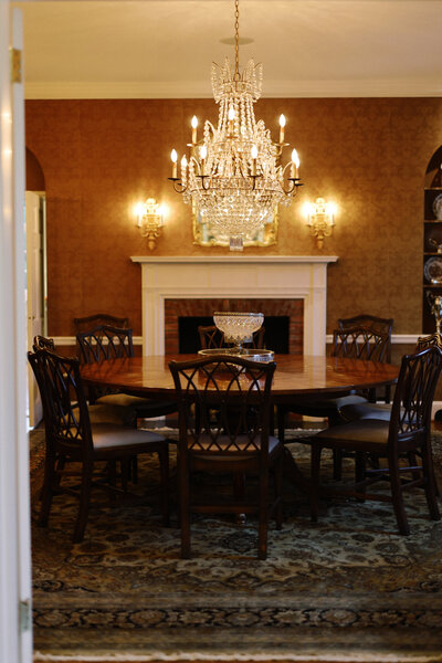 A spacious outdoor tent at Boxwood Estate, set up for a wedding with elegant decor. The tent is large enough to accommodate up to 350 guests, with long banquet tables arranged neatly underneath sparkling string lights. The open sides offer views of the surrounding lush greenery, and floral arrangements and candles add a romantic touch to the ambiance. The setting is both sophisticated and welcoming, perfect for a grand celebration.
