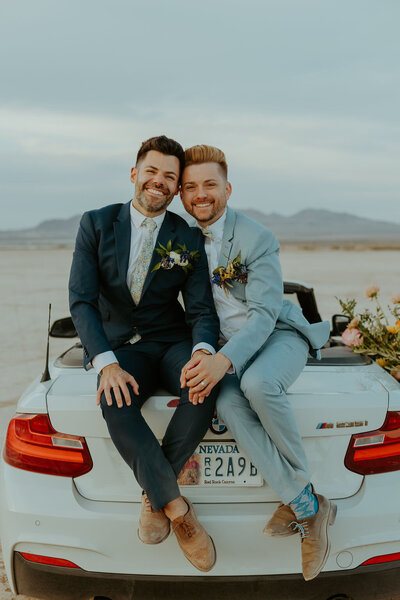 men together on back of car wedding
