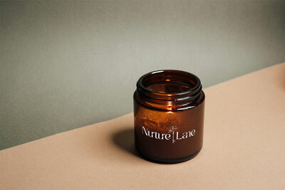 Nurture Lane Realty Branding Primary Logo on a Candle