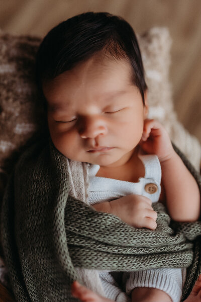  Close-up of a swaddled newborn baby boy sleeping peacefully during a natural light lifestyle newborn session in Southern California