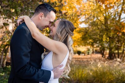 Bride a groom look each other in the eye with soft smiles