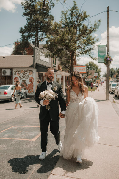 wedding couple walking along street holding hands