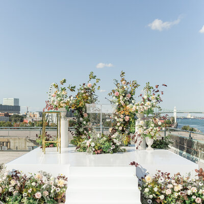 A wedding ceremony on the roof of the Science Centre decorated with a flower meadow and arch.