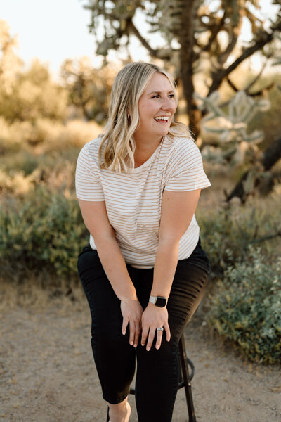 woman sits on stool in arizona landscape