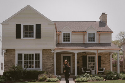 woman walks up to tudor house