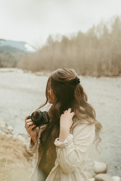 self portrait of a girl holding a camera looking away