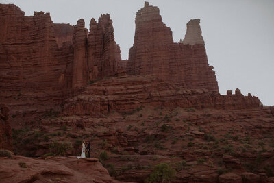 Bride and groom stand in the Moab desert on their elopement day.