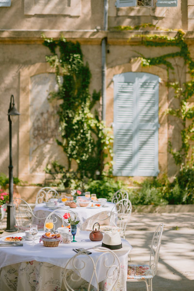 Laidback outdoor breakfast tables with white garden chairs for a Farewell Wedding Brunch in France
