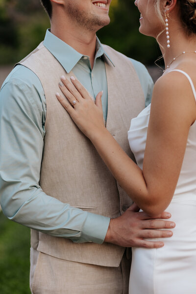 A close-up of a bride's ring resting on her groom's chest, captured at Lyons Farmette in Lyons, Colorado.