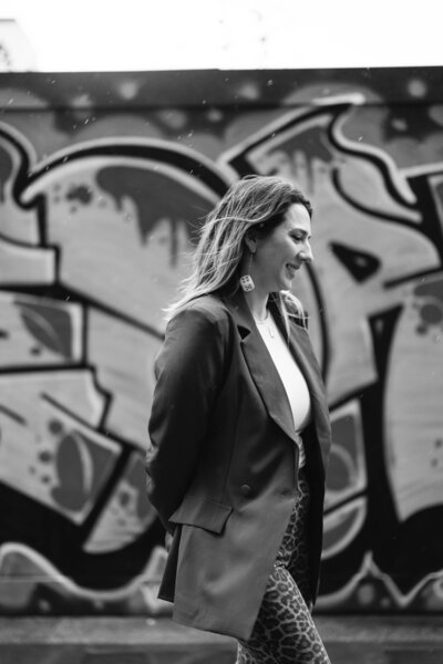 Emma, an Irish wedding planner & stylist, smiling with graphiti as the backdrop