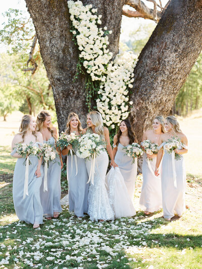 beautiful candid bridesmaid moment with floral tree installation