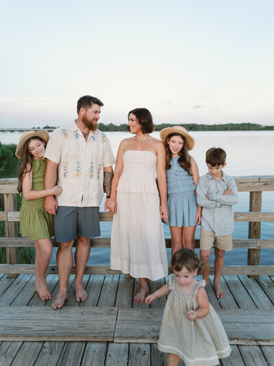 Family photo of Courtney Leigh and her husband and kids on a wooden bridge