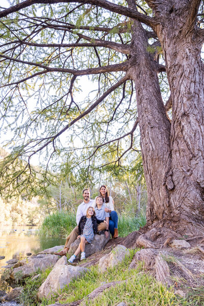 family posing underneath cypress trees
