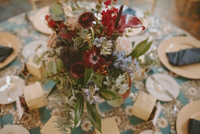 Wedding reception table of clear and green glass and bright flowers