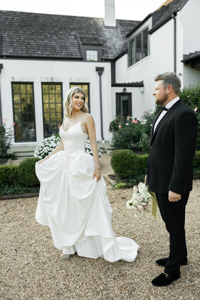 bride and groom outside looking at each other smiling