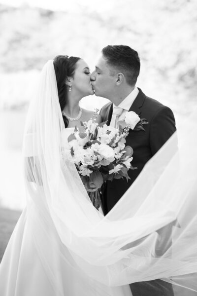 Austin-based wedding photographer captures a timeless black and white photo of a bride and groom kissing.
