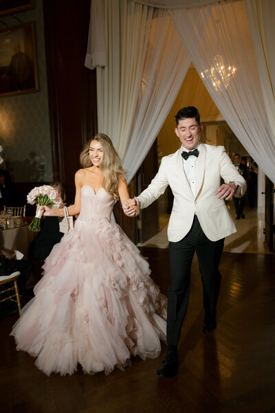 Candid direct flash photo of groom dancing in a luxury off-white tuxedo during a Philadelphia wedding reception.