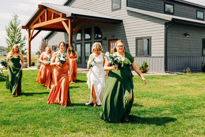 Bridesmaids walking on lawn at U Diamond Barn in Helena, MT