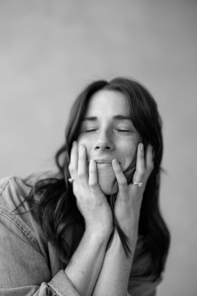 Lifestyle portrait of a photographer in their home studio with prints and gear