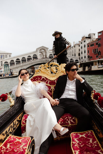 Bride and groom riding a Gondola through the canals of Venice on their elopement