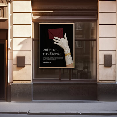 Large framed outdoor advertisement mounted on a stone building facade showing a gloved hand holding a burgundy envelope—an applied example of the event designer brand identity.