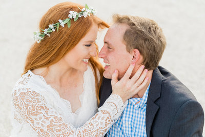 Bride with red hair and lace dress posing by window