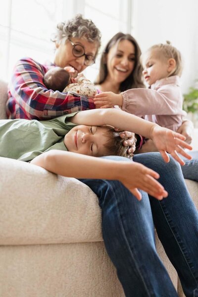 A joyful moment with three generations gathered around a newborn, captured during a Cleveland family photography session.