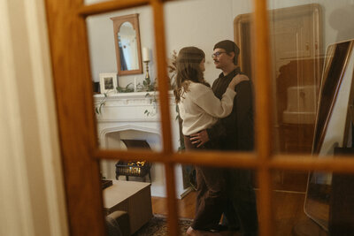 A couple dancing in their home, captured in an intimate and artistic wedding or engagement session.