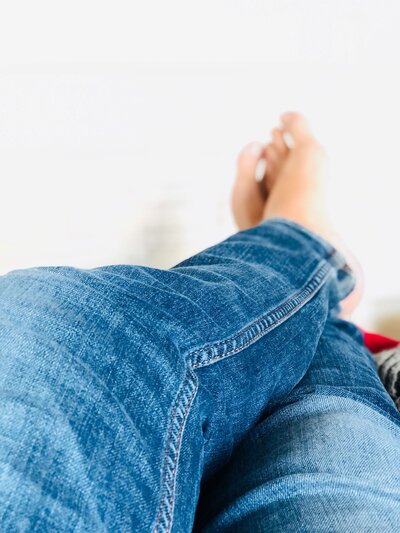 A picture of someone in jeans (legs only)