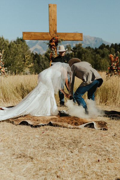 A wedding cake that is burnt orange and has white flowers on it
