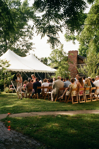 Guests waiting for the wedding to begin in front of a tent at a backyard wedding in Columbia, MO.