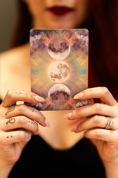 Intuitive human design coach holding tarot card