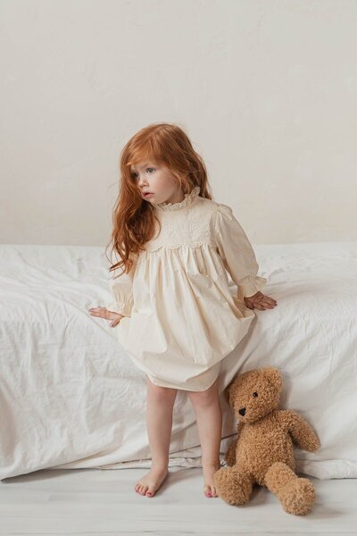 Little girl standing with teddy bear in soft natural light by a Michigan photographer