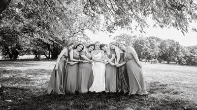 bride and bridesmaids holding hands and smiling
