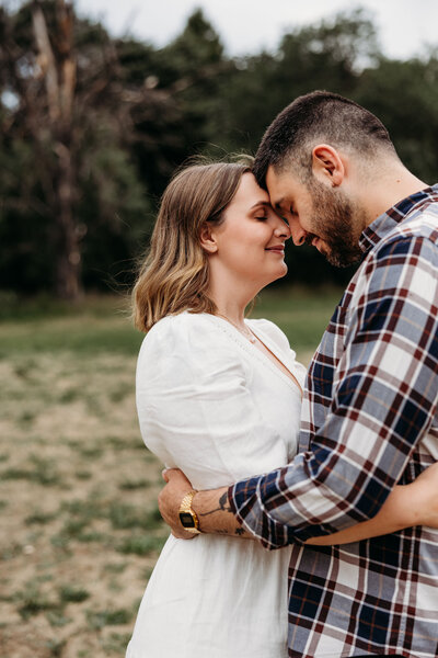 Husband and wife holding each other with their faces touching in a romantic way. Taken at Yarralumla, ACT. 