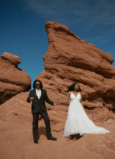 A couple stands among the red rocks on their Colorado elopement day