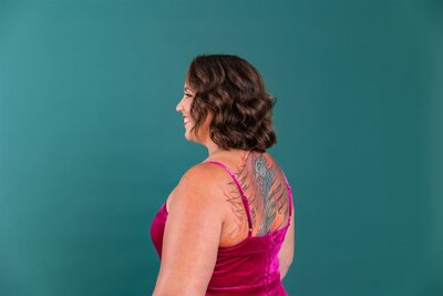 Woman in a pink jumpsuit with a large back tattoo