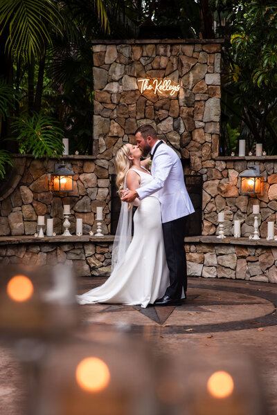 Bride and groom kissing surrounded by candles at San Diego wedding