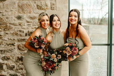 Bride and bridesmaids laughing under confetti at aswanley wedding venue