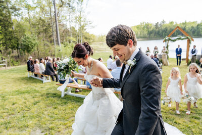 bride and groom smile at wedding ceremony at Carver Lake at Prospect Hill, NC