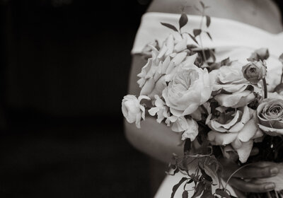 Black and white photo of bride holding florals