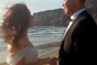 Oregon Coast beach with blurred eloping couple in foreground