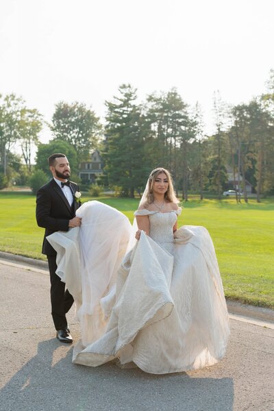 Groom holding brides dress