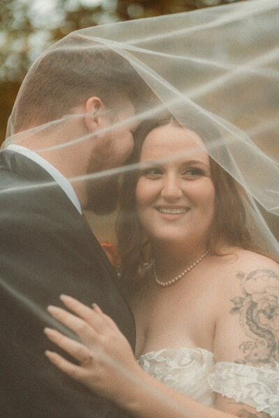 Couple posing together under veil during their elopement in Ontario.